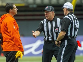 VANCOUVER, BC: SEPTEMBER 15, 2013 -- BC Lions head coach Mike Benevides, left in conversation with the referees as they play the Montreal Alouettes during first-half CFL regular season action at BC Place Stadium in Vancouver Sunday September 15, 2013. Benevides challenged two rulings during the course of the game.   (Ric Ernst / PNG)  (Story by sports)  TRAX #: 00023845A  & 00023847A [PNG Merlin Archive]