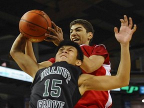 Walnut Grove guard Tom Guingab (front) battles Jesse Barnes of Queen Charlotte for a loose ball in Wednesday's 2014 Quad A tourney opener at the LEC. (Jason Payne, PNG)