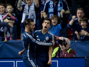 Sebastian Fernandez is congratulated by Russell Teibert after scoring a goal in the Vancouver Whitecaps' 4-1 win over the New York Red Bulls on March 8, 2014. CP photo.