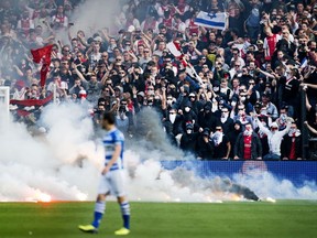 Flares thrown onto the pitch by fans interrupt the Dutch Cup final football match between Ajax Amsterdam and PEC Zwolle in Rotterdam on April 20, 2014. AFP OLAF KRAAK/AFP/Getty Images