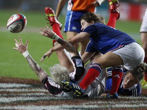 Canada's Jennifer Kish, left on the ground, is tackled by France's Jade Le Pesq, right, during the final match of Women's Invitational Cup at the Hong Kong Sevens rugby tournament in Hong Kong, Friday, March 28, 2014. Canada won 24-0. (AP Photo/ Kin Cheung) ORG XMIT: XVY101