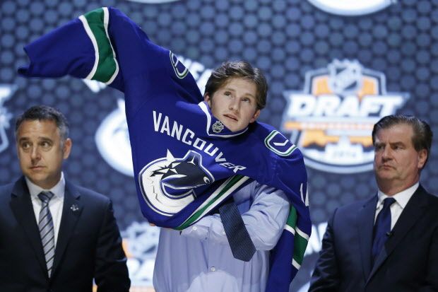 Jared Mccann pulls on a Vancouver Canucks sweater after being chosen 24th overall during the first round of the NHL hockey draft, Friday, June 27, 2014, in Philadelphia. (AP Photo/Matt Slocum) ORG XMIT: PX168