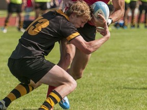 St. George’s Saints’ left wing Cathal Long (right) is tackled by outside centre Callahan McMaster of the Shawnigan Lake Stags during Saturday’s B.C. boys Triple A rugby championship final at Abbotsford’s Rotary Stadium. Saints scored late to win 15-12 and snap the Stags’ string of five straight provincial titles. (Photo by Rick MacDonald)