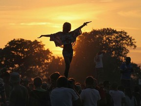 Girl dances above the crowd during this year's Glastonbury Festival in Somerset, England.