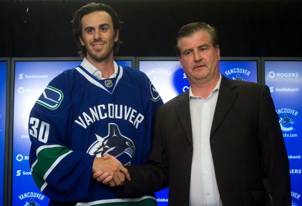 Vancouver Canucks' goalie Ryan Miller, left, shakes hands with general manager Jim Benning as they stand for photos during a news conference after Miller signed a three-year contract with the NHL hockey team in Vancouver, B.C., on Tuesday July 1, 2014. THE CANADIAN PRESS/Darryl Dyck ORG XMIT: VCRD102