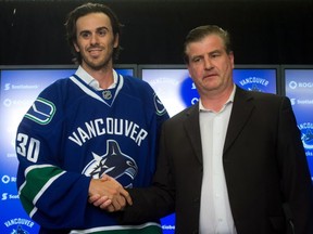 Vancouver Canucks' goalie Ryan Miller, left, shakes hands with general manager Jim Benning as they stand for photos during a news conference after Miller signed a three-year contract with the NHL hockey team in Vancouver, B.C., on Tuesday July 1, 2014. THE CANADIAN PRESS/Darryl Dyck