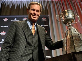 CFL Commissioner Mark Cohon poses with the Cup at the Commissioner's State of League Address in Toronto on Friday, November 23, 2012. THE CANADIAN PRESS/Sean Kilpatrick