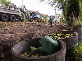 A watering can sits in a container as rews clear the land next to the CP rail line along East Boulevard in Vancouver.