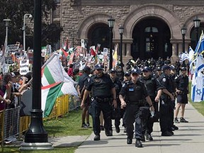 Police officers separate opposing Palestinian and Israeli supporters during a recent Toronto protest of the Israeli-Hamas conflict in the Middle East.