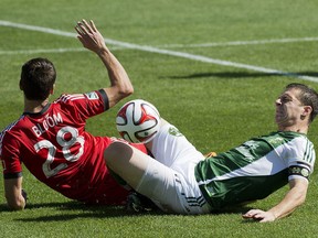 Toronto defender Mark Bloom collides with Portland midfielder Will Johnson, who broke his right leg on the play. (AP Photo/The Canadian Press, Nathan Denette)