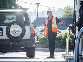 A worker serves a customer at at full service gas station in Coquitlam.
