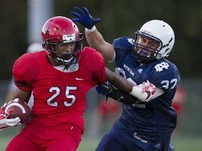 Notre Dame's Jordan Gabriele tries to put the stop to St. Thomas More running back Shane Noel during opening Friday Night Lights action at Burnaby Lakes. (Photo -- Gerry Kahrmann, PNG)