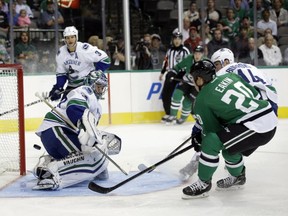 Vancouver Canucks goalie Ryan Miller (30) is unable to stop a score by Dallas Stars' Cody Eakin (20) during the first period of an NHL hockey game, Tuesday, Oct. 21, 2014, in Dallas. (AP Photo/Tony Gutierrez)