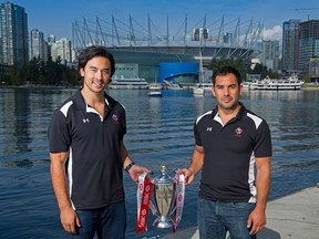 Nathan Hirayama (left) and Phil Mack of the Rugby Canada sevens team pose with the HSBC Sevens World Series trophy. (Photo by Rich Lam/Getty Images)