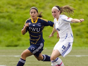 Trinity Western’s Casandra Siveri (left) keeps UBC’s Megan Pasternak under close wraps Sunday during the Canada West regular season soccer finale for both teams at Thunderbird Stadium. UBC won 1-0 and will play at TWU this Friday in the opening round of conference playoffs. (Photo — Wilson Wong, UBC athletics)