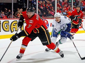 Jannik Hansen chases down TJ Brodie of the Calgary Flames on Wednesday in Calgary.