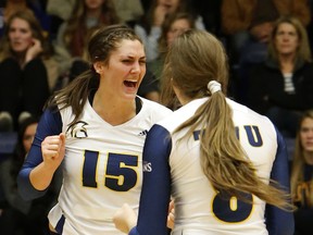 Trinity Western Spartans’ middle blocker Alicia Perrin (left) celebrates a point with teammate Katie Devaney. The Spartans open Canada West conference play Friday, hosting Kamloops’ Thompson Rivers WolfPack at the Langley Events Centre. (Photo — Scott Stewart, Trinity Western athletics)