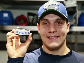 Bo Horvat displays his game puck after scoring his first NHL goal against the Anaheim Ducks on Thursday night. He must be new: that's a full set of teeth right there. (Jeff Vinnick, NHL/Getty Images)