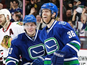 VANCOUVER, BC - NOVEMBER 23:  Bo Horvat #53 congratulates Jannik Hansen #36 of the Vancouver Canucks after he scored his third goal against the Chicago Blackhawks during their NHL game at Rogers Arena November 23, 2014 in Vancouver, British Columbia, Canada. (Photo by Jeff Vinnick/NHLI via Getty Images)