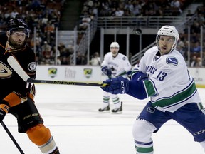 Vancouver Canucks center Nick Bonino, right, knocks the puck away from Anaheim Ducks left wing Patrick Maroon during the first period of an NHL hockey game in Anaheim, Calif., Sunday, Nov. 9, 2014. (AP Photo/Chris Carlson)