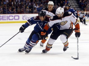 Colorado Avalanche left wing Cody McLeod, left, reaches out for puck as Anaheim Ducks center Ryan Kesler covers in the third period of the Ducks' 3-2 victory in an NHL hockey game in Denver on Sunday, Nov. 2, 2014. (AP Photo/David Zalubowski)