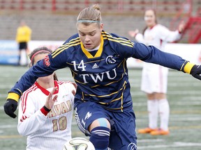 Trinity Western striker Krista Gommeringer (right) attempts to hold off Laval’s Arielle Roy-Petiticlerc during Sunday’s CIS women’s soccer final at the Universite Laval. The host Rouge et Or won the national title by a resounding 5-0 score. (Scott Stewart, TWU athletics)
