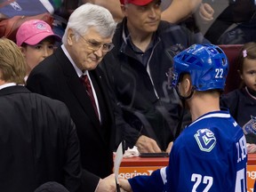 Former Vancouver Canucks' president and general manager Pat Quinn, left, shakes hands with Daniel Sedin, of Sweden, as he leaves the ice after being inducted into the team's Ring of Honour before an NHL hockey game against the Calgary Flames in Vancouver, B.C., on Sunday April 13, 2014. THE CANADIAN PRESS/Darryl Dyck
