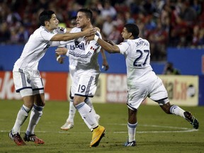 Vancouver's Matias Laba, left, and Ethen Sampson (27), celebrate wth Erik Hurtado (19) after Hurtado's score against FC Dallas in the second half of an MLS playoff soccer match, Wednesday, Oct. 29, 2014, in Frisco, Texas. FC Dallas scored on a penalty kick late in the match helping them to the 2-1 win over Vancouver. (AP Photo/Tony Gutierrez)