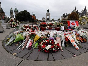 The killings of Cpl. Nathan Cirillo at the National War Memorial, pictured covered in floral tributes, and Warrant Officer Patrice Vincent  have given special significance to Remembrance Day this year. (CP files)