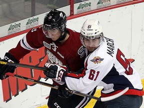Andrey Pedan (left) battles with Windsor Spitfires Chris Marchese during his Guelph Storm days in 2012.