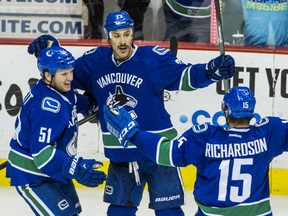 VANCOUVER, BC: NOVEMBER 25, 2014 -- Vancouver Canucks Derek Dorsett, left and Brad Richardson, right celebrate with Shawn Matthias, centre after he scores on the New Jersey Devils during the third period of a regular-season NHL game at Rogers Arena in Vancouver, B.C. Tuesday November 25, 2014.  (Ric Ernst / PNG)  (Story by Ben Kuzma & Iain McIntyre)  TRAX #: 00033253A & 00033253B [PNG Merlin Archive]