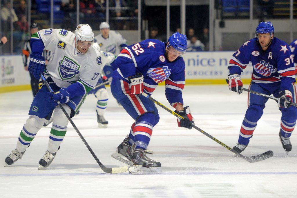 Tina Russell / Observer-Dispatch    From left, Utica Comets player Tom Sestito brings the puck down the ice as Rochester Americans player Brady Austin defends during AHL hockey at the Utica Memorial Auditorium Wednesday, Dec. 10, 2014.