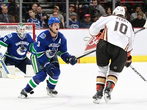 VANCOUVER, BC - NOVEMBER 20:  Kevin Bieksa #3 of the Vancouver Canucks grimaces as he blocks a shot by Corey Perry #10 of the Anaheim Ducks during their NHL game at Rogers Arena November 20, 2014 in Vancouver, British Columbia, Canada. Anaheim won 4-3 in a shootout. (Photo by Jeff Vinnick/NHLI via Getty Images)