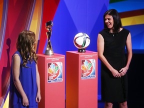 Canadian National women's team captain Christine Sinclair smiles while on stage next to the official match ball and the FIFA Women's World Cup trophy during the FIFA Women's World Cup Canada 2015 tournament final draw, held at the Canadian Museum of History in Gatineau, Canada, on December 6, 2014.  (Cole Burston/AFP/Getty Images)