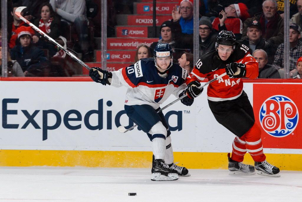 MONTREAL, QC - DECEMBER 26:  Martin Reway #10 of Team Slovakia and Jake Virtanen #18 of Team Canada chase the puck during the 2015 IIHF World Junior Hockey Championship game at the Bell Centre on December 26, 2014 in Montreal, Quebec, Canada.  (Photo by Minas Panagiotakis/Getty Images)