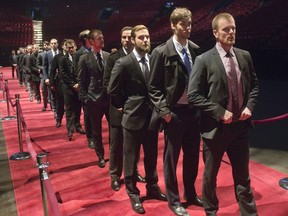 Members of the Vancouver Canucks line up to pay their respects during the visitation at the Bell Centre Monday, December 8, 2014 in Montreal. The Montreal Canadiens hockey legend passed away Tuesday, Dec. 2, 2014 at the age of 83.THE CANADIAN PRESS/Ryan Remiorz