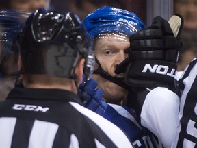 Vancouver Canucks' Jannik Hansen, of Denmark, looks at referee Trevor Hanson as he takes a glove to the face from Dallas Stars' Trevor Daley during the first period of an NHL hockey game in Vancouver, B.C., on Wednesday December 17, 2014. THE CANADIAN PRESS/Darryl Dyck