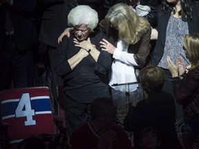 Elise Beliveau is consoled by her daughter Helene as she is overcome by emotion as she stands next to her husband Montreal Canadiens legend Jean Beliveau's empty seat, during a ceremony prior to facing the Vancouver Canucks in NHL hockey action Tuesday, December 9, 2014 in Montreal. Beliveau died last week at the age of 83 with funeral services to be held Wednesday. THE CANADIAN PRESS/Paul Chiasson