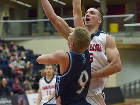 Simon Fraser University forward Patrick Simon looks for a lay-up over Capilano University guard Andrew Morris in Men's Basketball at SFU West Gym on Tuesday. (Ron Hole, SFU athletics)