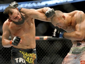 Johny Hendricks, left, and Robbie Lawler exchange punches during a UFC 171 mixed martial arts welterweight title bout, Saturday, March 15, 2014, in Dallas. Hendricks won by decision. (AP Photo/Matt Strasen)