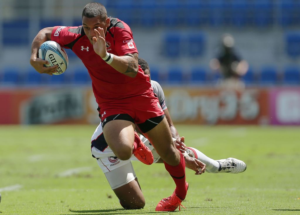 GOLD COAST, AUSTRALIA - OCTOBER 11:  Mike Fuailefau of Canada is tackled during the 2014 Gold Coast Sevens Pool D match between the United States and Canada at Cbus Super Stadium on October 11, 2014 in Gold Coast, Australia.  (Photo by Mark Metcalfe/Getty Images)