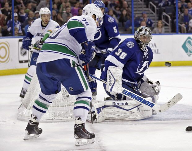 Tampa Bay Lightning goalie Ben Bishop (30) makes a save on a shot by Vancouver Canucks left wing Chris Higgins (20) during the third period of an NHL hockey game Tuesday, Jan. 20, 2015, in Tampa, Fla. The Lightning won 4-1. (AP Photo/Chris O'Meara)
