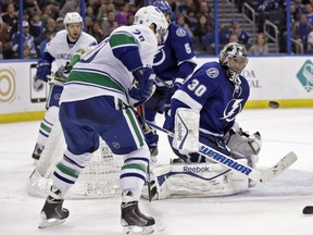 Tampa Bay Lightning goalie Ben Bishop (30) makes a save on a shot by Vancouver Canucks left wing Chris Higgins (20) during the third period of an NHL hockey game Tuesday, Jan. 20, 2015, in Tampa, Fla. The Lightning won 4-1. (AP Photo/Chris O'Meara)