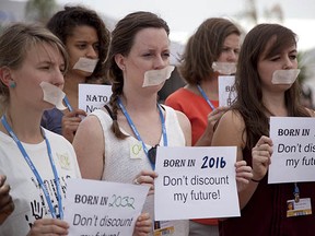 Activists from different countries hold signs in support of the unborn on the sidelines of the Climate Change Conference last month on a beach in Lima, Peru. The largest global-warming agreement ever could potentially be signed later this year.