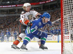 VANCOUVER, BC - JANUARY 27:  Hampus Lindholm #47 of the Anaheim Ducks checks Jannik Hansen #36 of the Vancouver Canucks during their NHL game at Rogers Arena January 27, 2015 in Vancouver, British Columbia, Canada.  Anaheim won 4-0. (Photo by Jeff Vinnick/NHLI via Getty Images)