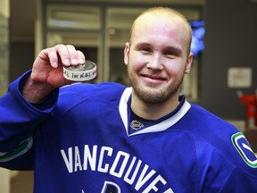 Alex Biega displays the puck after scoring his first NHL goal in his first NHL game, the winning tally against the Minnesota Wild during their NHL game at Rogers Arena Feb. 16. (Photo by Jeff Vinnick/NHLI via Getty Images)