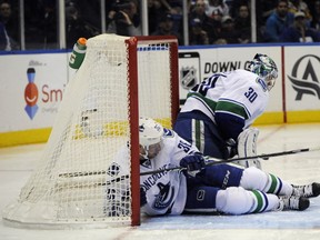 Jannik Hansen collides with goalie Ryan Miller in the net in the second period of the Canucks vs. Islanders game at Nassau Coliseum on Sunday, Feb. 22, 2015, in Uniondale, N.Y. Miller left the game with a leg injury and was replaced by Eddie Lack. The Canucks won 4-0. (AP Photo/Kathy Kmonicek)