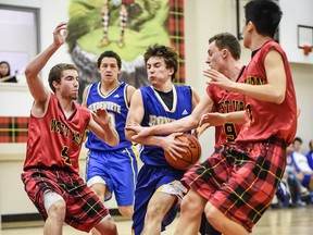 Making plaid a real defensive pattern, West Vancouver Highlanders’ players (l to r) Trevor Fonseca, Grady Huskisson and Timothy Lin lock down on North Vancouver’s visiting Handsworth Royals during a Jan. 13 Howe Sound conference clash won 58-53 by the hosts at West Van’s tartan-inspired gymnasium. (Blair Shier Photography)