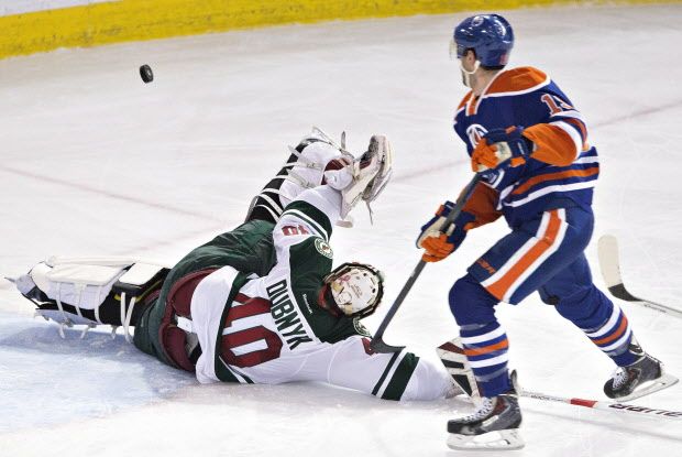 Minnesota Wild goalie Devan Dubnyk (40) makes the same on Edmonton Oilers' Justin Schultz (19) during second period NHL hockey action in Edmonton, Alta., on Tuesday January 27, 2015. THE CANADIAN PRESS/Jason Franson