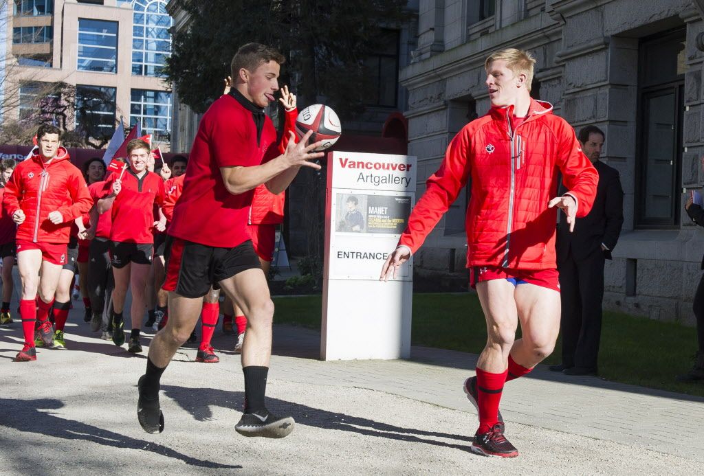 VANCOUVER,BC:FEBRUARY 23, 2015 -- Canadian Rugby Sevens team member John Moonlight passes the ball to Fraser Hurst at the Vancouver Art Gallery in downtown Vancouver, BC, during a ball relay from Victoria to announce the award of Vancouver as a stop in the The World Rugby Sevens Series, February, 23, 2015. (Richard Lam/PNG) (For ) 00034981A [PNG Merlin Archive]